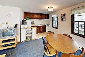a kitchen with a dining room table and a television at Dennis Port Palace in Dennis Port