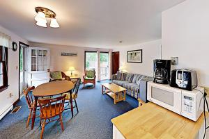 a living room with a table and a couch at Dennis Port Palace in Dennis Port