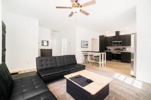 a living room with a black couch and a table at Stay Awhile in Honor