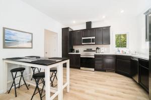 a kitchen with black cabinets and a table with stools at Stay Awhile in Honor +17 photos