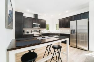 a kitchen with black cabinets and stainless steel appliances at Stay Awhile in Honor