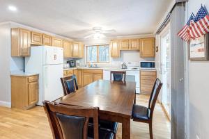 a kitchen with a table and chairs and a refrigerator at Lighthouse Lodge in Eastham