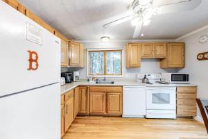 a kitchen with wooden cabinets and a white refrigerator at Lighthouse Lodge in Eastham