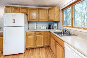 a kitchen with wooden cabinets and a white refrigerator at Lighthouse Lodge in Eastham +19 photos