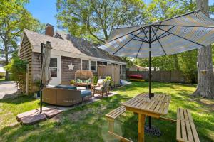 a patio with a table and an umbrella in a yard at Dolce Vita in Falmouth