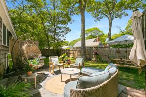 a patio with chairs and tables and a fence at Dolce Vita in Falmouth