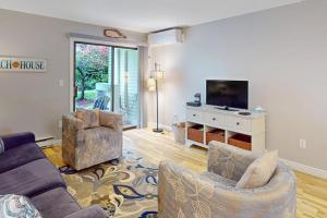 ein Wohnzimmer mit zwei Sofas und einem Flachbildfernseher in der Unterkunft Sand, Shells & Sunsets in Brewster
