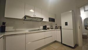 a kitchen with white cabinets and a refrigerator at Odivelas Place 1 in Odivelas +19 photos