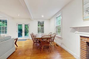 a living room with a table and chairs and a fireplace at Family Tides in Barnstable
