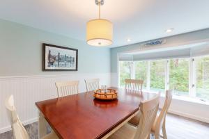 a dining room with a wooden table and chairs at Beach Happy in Harwich Port