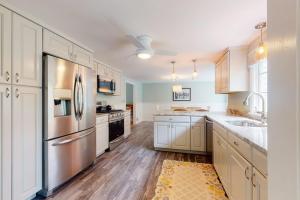 a kitchen with white cabinets and stainless steel appliances at Beach Happy in Harwich Port