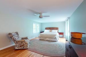 a bedroom with a bed and a chair at Beach Happy in Harwich Port