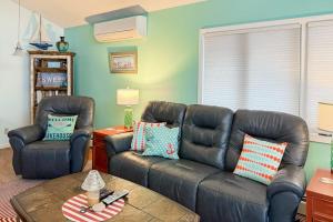 a living room with a leather couch and two chairs at Cherry Fish North in Beulah