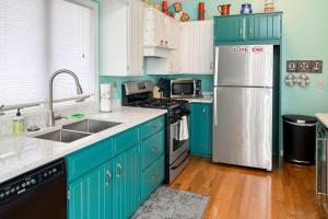 a kitchen with blue cabinets and a white refrigerator at Cherry Fish North in Beulah +26 photos