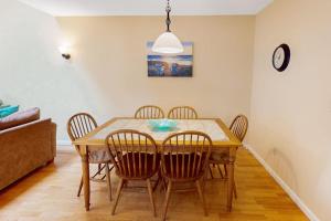 a dining room table with chairs and a clock on the wall at Ocean Edge Retreat in Brewster