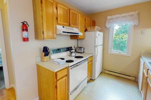 a kitchen with a stove and a white refrigerator at Ocean Edge Retreat in Brewster