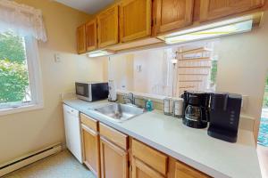 a kitchen with a sink and a microwave at Ocean Edge Retreat in Brewster
