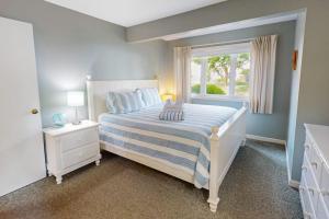 a bedroom with a large bed with a window at Ocean Edge Retreat in Brewster +19 photos