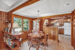 a kitchen with wooden walls and a table and chairs at Cedar Cot & Cedar Tot in Beulah