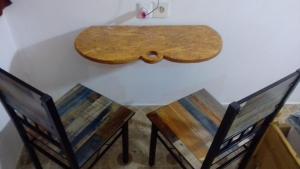a table with two chairs and a wooden board on the wall at Cafe Romantique - Landhouse Style in Mérina