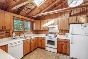 a kitchen with wooden cabinets and a white refrigerator at Cedar Cot & Cedar Tot in Beulah +24 photos