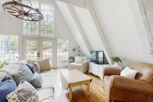 a living room with a couch and a tv at Mt McSauba A Frame Cottage in Charlevoix