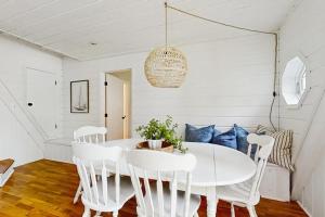 a white dining room with a white table and chairs at Mt McSauba A Frame Cottage in Charlevoix