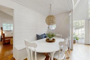 a white dining room with a white table and chairs at Mt McSauba A Frame Cottage in Charlevoix
