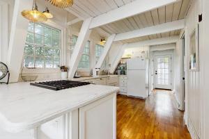 a kitchen with white cabinets and a white refrigerator at Mt McSauba A Frame Cottage in Charlevoix