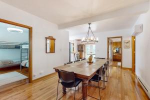 a dining room with a wooden table and chairs at Steps from the Sand in Union Pier +18 photos
