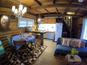 a living room with a table and a kitchen in a cabin at Casa de toras in Campo Alegre
