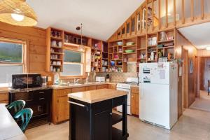 a kitchen with wooden cabinets and a white refrigerator at Walloon Lake Cottage in Boyne City