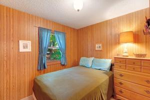 a bedroom with a bed and a dresser and a window at Walloon Lake Cottage in Boyne City