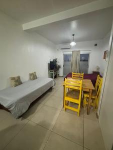 a bedroom with a bed and a table and chairs at Experiencia Brown a Mtros Sanatorio Juncal in Temperley