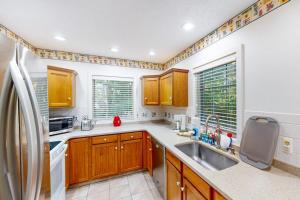 a kitchen with wooden cabinets and a stainless steel refrigerator at Lou n' Lil's in Glen Arbor