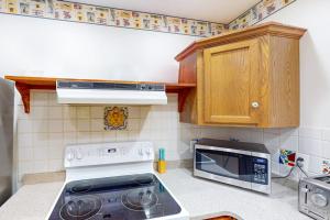 a kitchen with a stove and a microwave at Lou n' Lil's in Glen Arbor