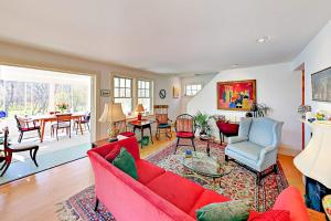 a living room with a red couch and chairs at Brookview Bungalow in South Wellfleet