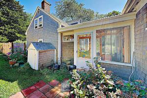 a small house with a door and a garden at Brookview Bungalow in South Wellfleet
