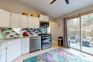 a kitchen with white cabinets and a stove top oven at Four Bedrooms & a Beach in Lakeside