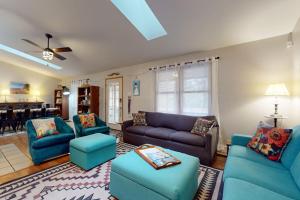 a living room with blue couches and a dining room at Four Bedrooms & a Beach in Lakeside