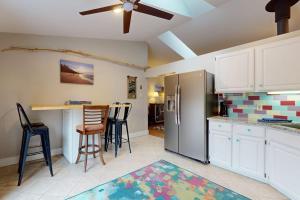 a kitchen with a refrigerator and a table and chairs at Four Bedrooms & a Beach in Lakeside +17 photos
