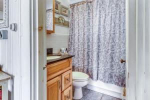 a bathroom with a toilet and a shower curtain at Sea la Vie in Harwich