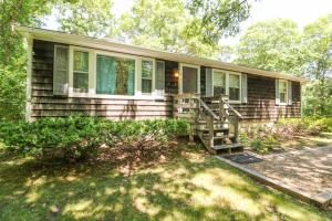 a small house with a porch and a yard at Sea Glen Cottage in Oak Bluffs