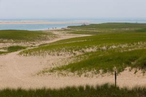 a sandy beach with people walking on the beach at Sea Glen Cottage in Oak Bluffs