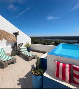 a patio with two chairs and a swimming pool at Casa Lusa Montargil in Montargil
