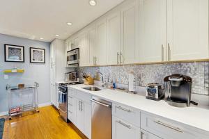 a kitchen with white cabinets and a sink at Provincetown Waterfront Studio in Provincetown