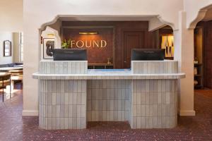 a lobby with a round counter with two laptops on it at FOUND Hotels, Santa Barbara, Series by Marriott in Santa Barbara +40 photos