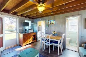 a kitchen with a dining room table and a ceiling fan at Sea Coast Cottage in Barnstable