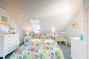 a bedroom with a bed with a colorful bedspread at Sea Coast Cottage in Barnstable