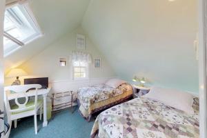 a attic bedroom with two beds and a desk at Sea Coast Cottage in Barnstable +25 photos